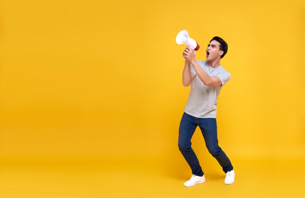young-asian-man-shouting-into-megaphone-making-ann-2024-12-06-04-51-00-utc-web